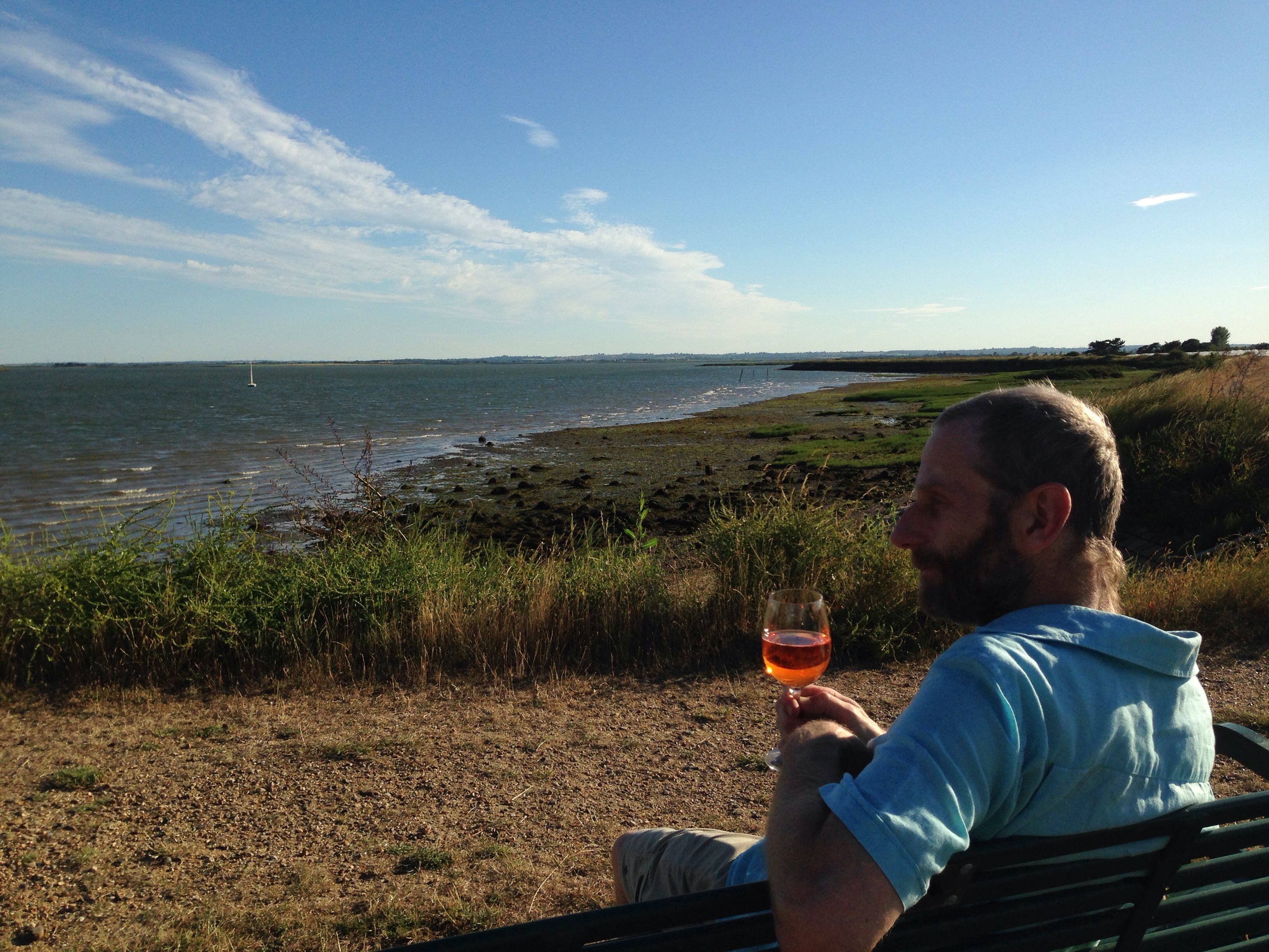 Photo of Stephen with glass of wine in hand sitting by the Blackwater Estuary
